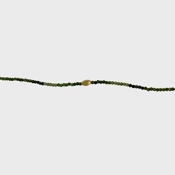 Green tourmaline bracelet with single gold bead and clasp close-up